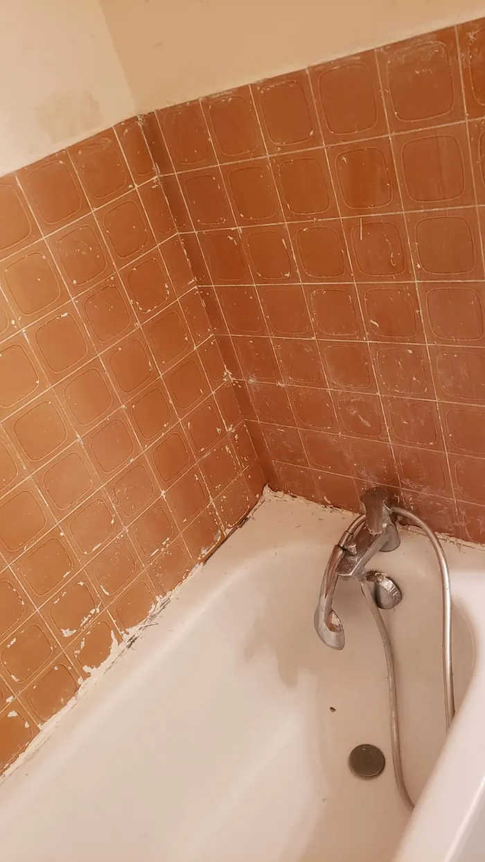 Le même angle de baignoire après décapage de la faïence et remise en état.